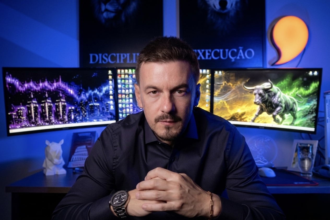 Responsável pela Vírgula Invest em sua estação de trabalho, com quadros de disciplina e execução ao fundo.